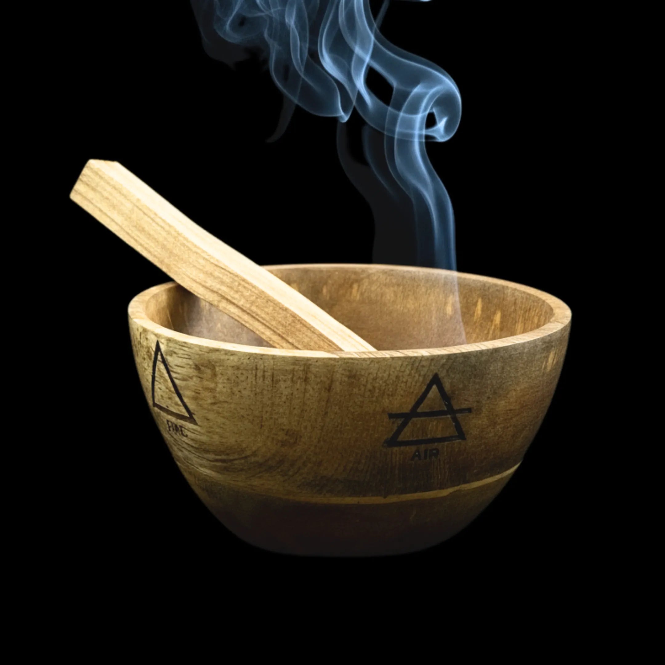 Bol en bois de manguier, symboles des 4 éléments gravés, avec bâton de Palo Santo allumé à l'intérieur, sur fond noir.