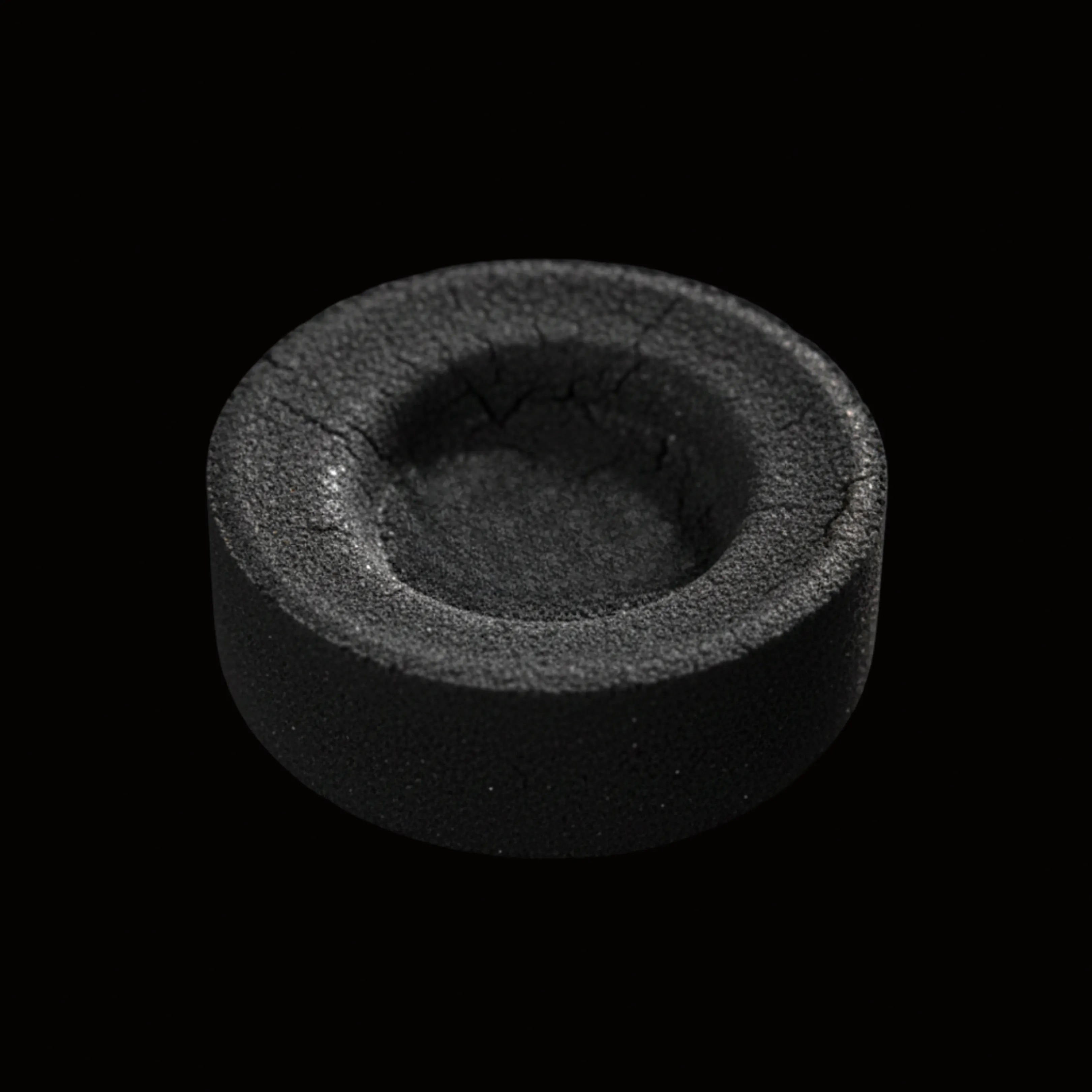 Palet de charbon ardent vu de face sur fond noir.